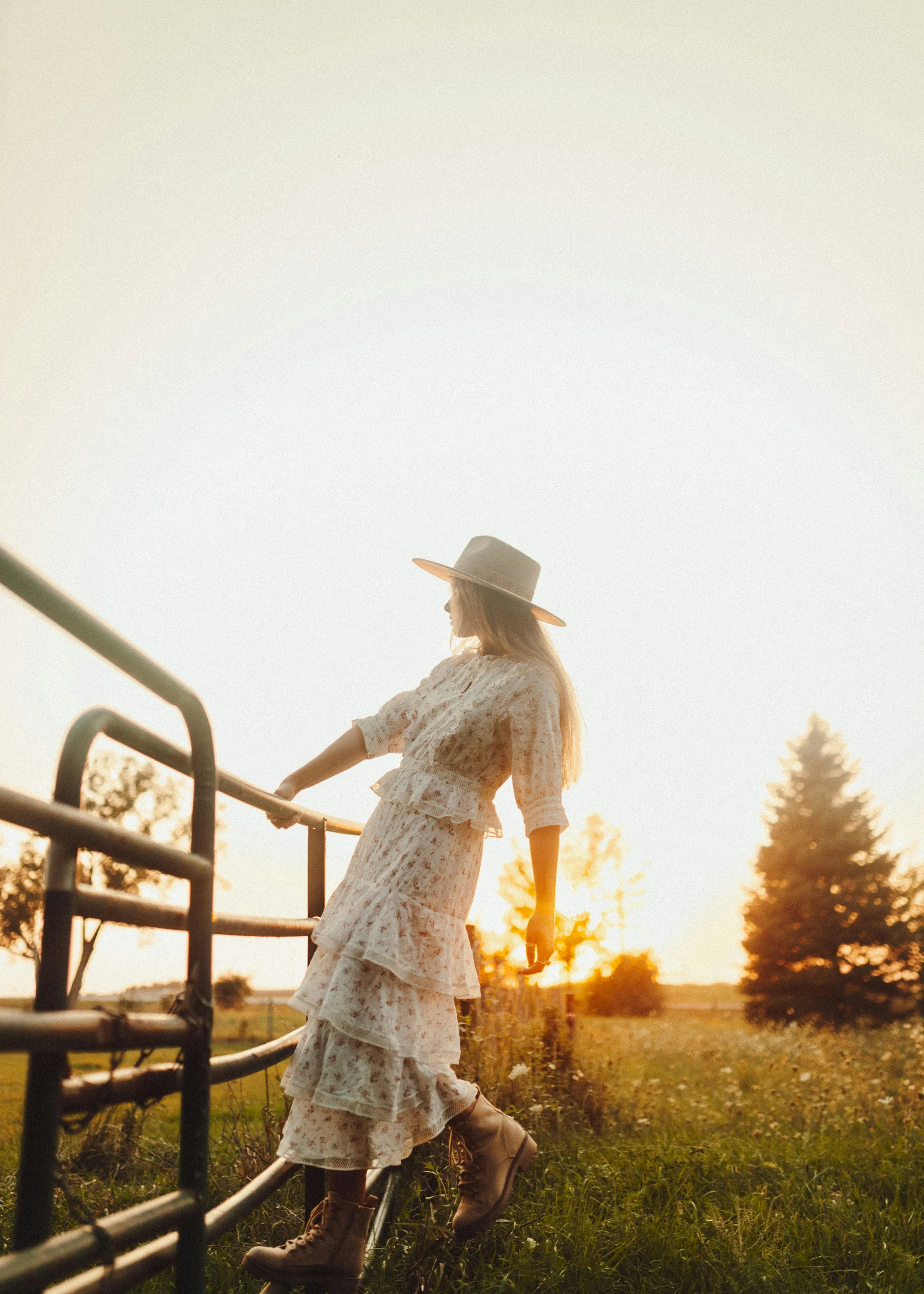 Girl on a fence wearing a white dress